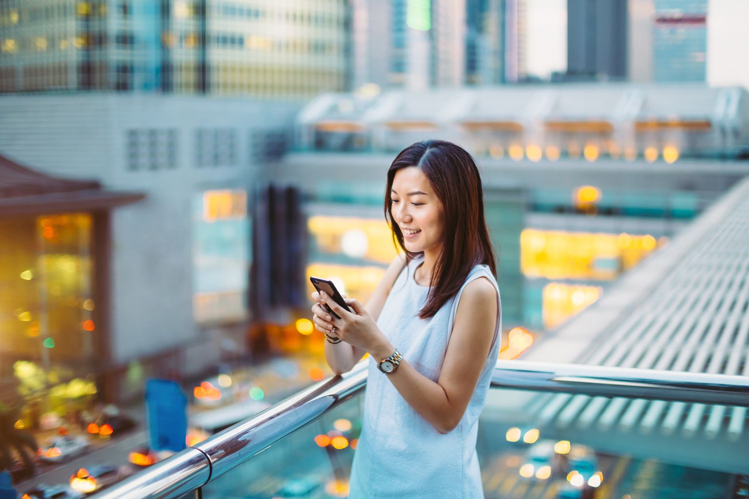 Pretty young businesswoman text messaging on smartphone