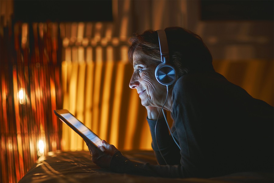 mujer con auriculares viendo la TV