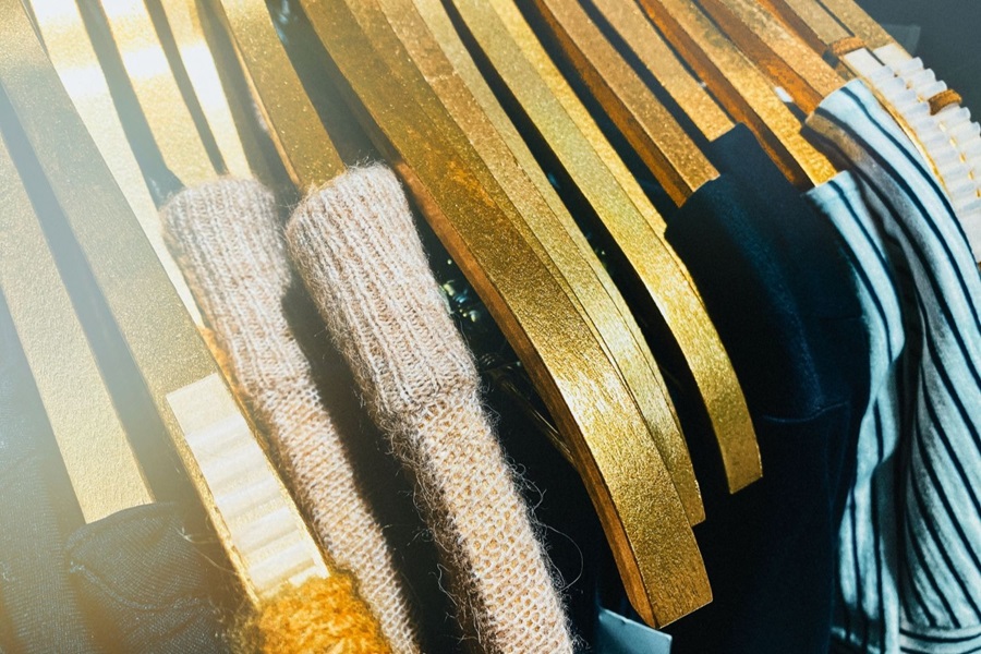 Gold hangers with clothing items hanging in wardrobe